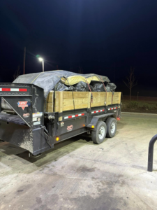 A trailer loaded with black trash bags and large items, ready for disposal by Next Level Waste Group LLC in Kansas City, MO.