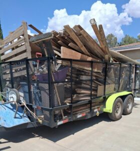 A large trailer overflowing with wood debris, pallets, and construction waste for removal by Roadrunner JunkSmart Solutions LLC in Las Cruces, NM.
