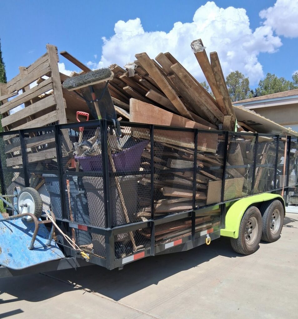 A large trailer overflowing with wood debris, pallets, and construction waste for removal by Roadrunner JunkSmart Solutions LLC in Las Cruces, NM.