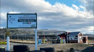 The entrance to the Windham Solid Waste Management District Transfer Station in Brattleboro, VT, with a sign and scale house.