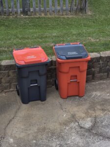Two branded trash and recycle bins from Trash Pandas LKN, placed outdoors in Charlotte, NC.