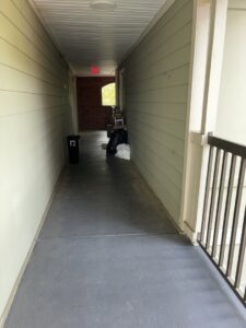 Trash bags and a bin placed in an apartment hallway, ready for pickup by A1 Valet Trash in Atlanta, GA.