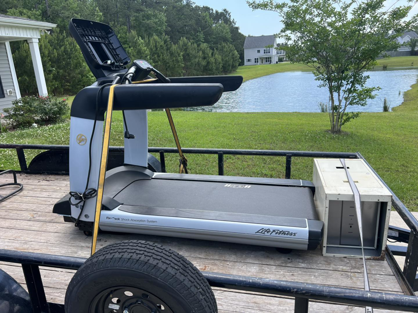 A treadmill and old appliance loaded onto a trailer for removal by All That Junk Removal in Wilmington, NC.