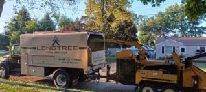 A Longtree Tree Service chipper truck processing branches after a tree removal job in Southfield, MI.
