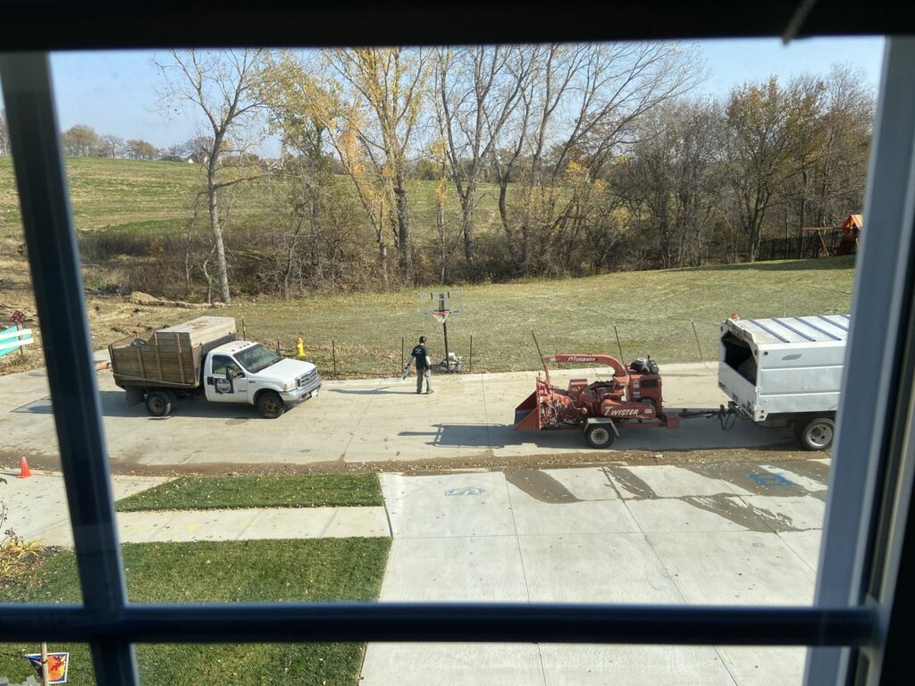 A tree service worker feeding branches into a wood chipper attached to a truck for South "O" Tree and Stump in Omaha, NE.