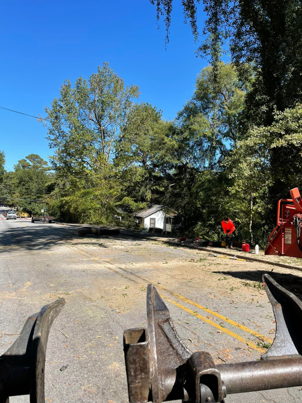 Tree debris cleanup on a street with a wood chipper and heavy equipment by Trees of Georgia Tree Service in Roswell, GA.