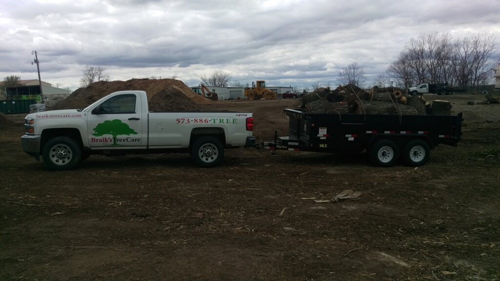 A tree service truck and trailer loaded with tree debris after a job by Braik's Tree Care in Columbia, MO.