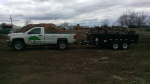 A tree service truck and trailer loaded with tree debris after a job by Braik's Tree Care in Columbia, MO.