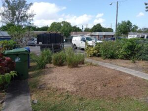 A white pickup truck with a large trailer filled with tree debris, ready for removal by MJ'z Tree and Landscaping Service LLC in Fort Lauderdale, FL.