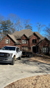 A white pickup truck with a trailer full of tree debris, ready for removal after a tree service job by Sunny Meadows Land and Tree LLC in Birmingham, AL