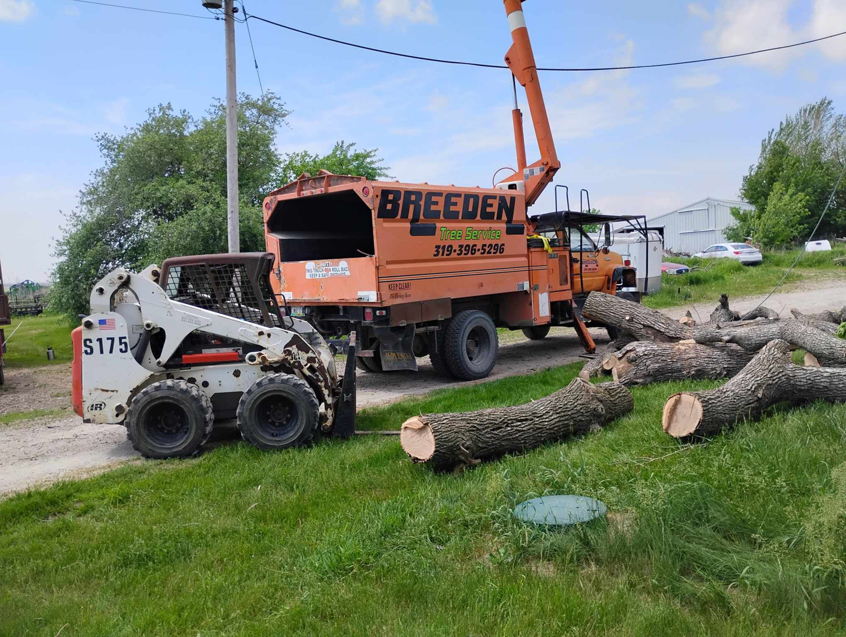 Tree removal and chipping equipment with cut logs at Breeden Tree Service in Cedar Rapids, IA
