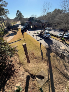 A crane truck lifting a section of a tree log during a tree removal operation by Hall's Tree Service in Paw Paw, MI.