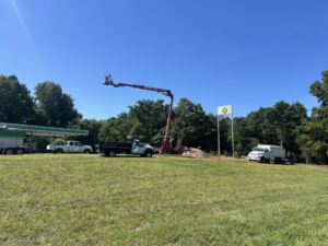 Tree service equipment, including a bucket lift with a worker, on a job site for Carter's Tree & Stump in Greensboro, NC