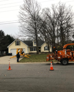 Tree removal equipment, including a chipper and lift, set up in front of a house for a job by Ratliff Landscape and Tree Service LLC in Murfreesboro, TN