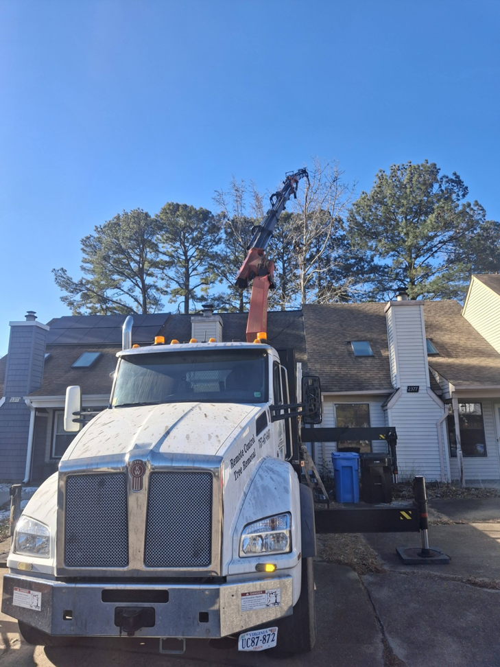 A large tree removal truck with an extended crane ready for service by Alley's Tree Service in Va Beach, VA.