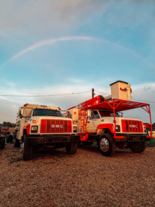Two GMC trucks, including a bucket truck and a chip truck, used by Tharp's Lawn Care & Tree Service in Indianapolis, IN