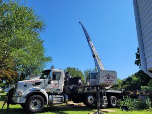 A branded crane truck from Mike's Professional Tree Service parked on a lawn, ready for tree removal in Coventry, RI.