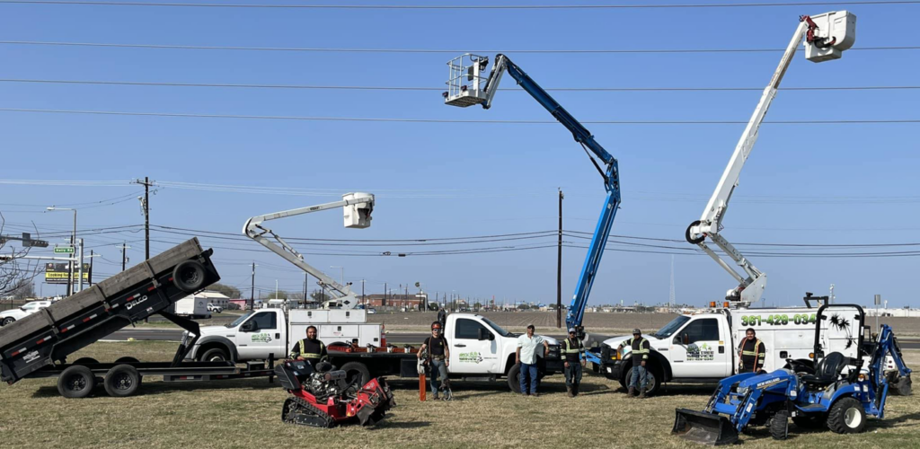 A tree service crew standing with their bucket trucks, trailer, and equipment at JRs PALM TREE SERV. in Corpus Christi, TX.