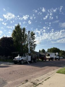 Custom Cuts Tree Service crew and equipment on a residential street in Watertown, SD, for tree work.