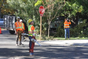 A tree service crew with equipment and a debris trailer at a roadside job site for A Better Tree Service in Sacramento, CA.