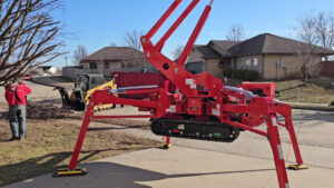 Tree service equipment, including a spider lift and skid steer, with debris on the ground for Braik's Tree Care in Columbia, MO.