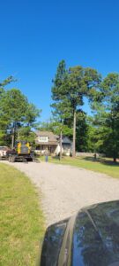 Tree service equipment, including a Bobcat on a trailer, arriving at a job site for J & K Tree Service in Robbins, NC.