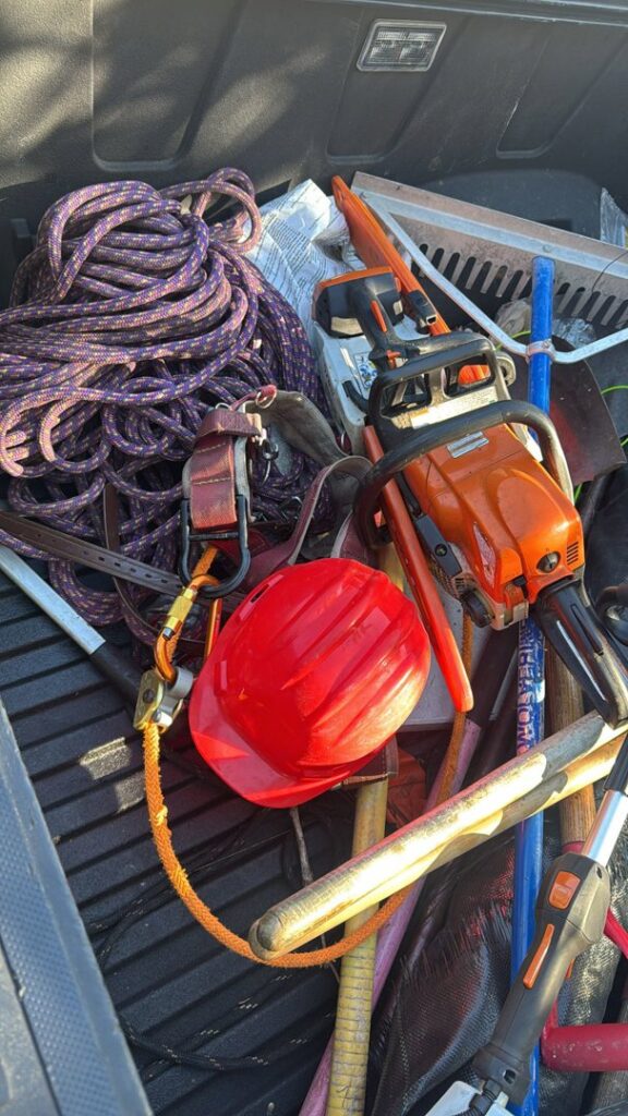 Essential tree service equipment including a chainsaw, ropes, and a hard hat, used by Tree service of south florida inc in Fort Lauderdale, FL.