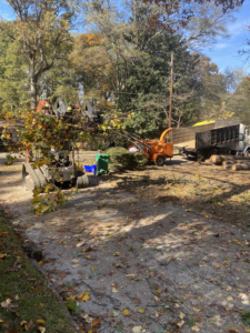 Tree service equipment including a chipper and excavator on a job site with debris by Sergeant tree service in Atlanta, GA