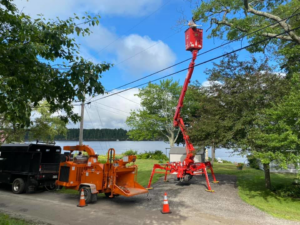Tree service equipment, including a wood chipper and spider lift, at a job site by Fagan Tree Service in Brunswick, ME.