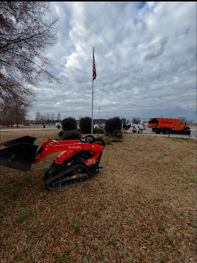 A Kubota mini skid steer and a chipper truck ready for tree service work by Castle Tree Service in Conway, AR.