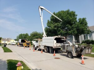 Tree service equipment, including a bucket truck and chipper, set up on a residential street by M S Wiekhorst Arbor Company in Columbus, NE.