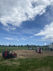 Heavy tree service equipment, including a stump grinder and skid steer, on a job site for Detail Tree works & landscaping in Denver, CO.