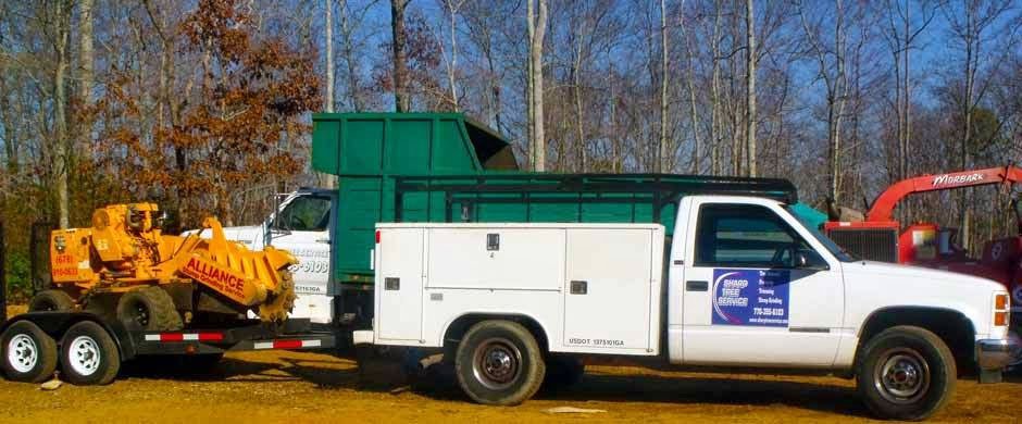 Tree service equipment, including a stump grinder and chipper truck, ready for work by Sharp Tree Service in Cumming, GA.