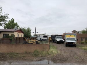 Multiple Kiki's Tree Service vehicles and equipment parked at a residential job site in Albuquerque, NM.