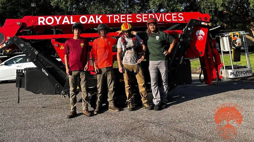 The Royal Oak Tree Services team standing proudly in front of their red tree service equipment in Jacksonville, FL.