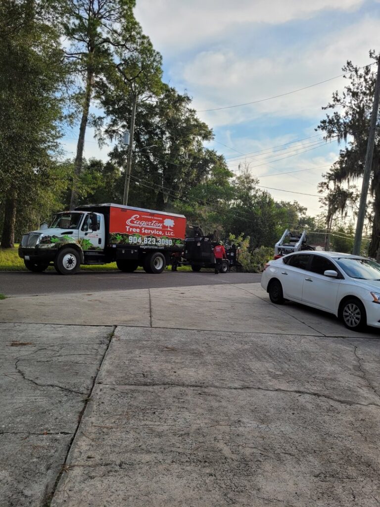 A tree service truck from Eagerton Tree Service, LLC pulling a wood chipper, with crew members working in Ponte Vedra Beach, FL.