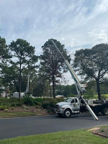A tree service truck with its boom extended, ready for work by Timber Tree Service Incorporated in Theodore, AL.