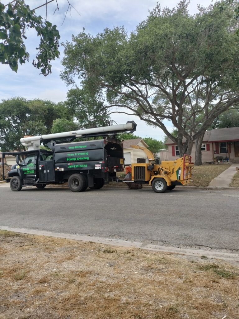 A C & N Tree Service truck with a bucket lift and wood chipper, ready for tree removal in Corpus Christi, TX.