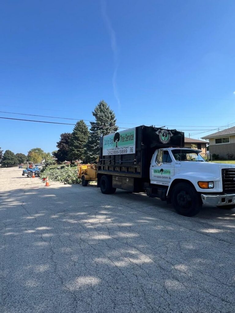 A Cutting Edge Tree Service truck with a wood chipper attached, ready for branch removal in Racine, WI.