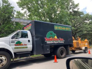 Yates Tree Inc. tree service truck with a wood chipper attached, ready for work in San Antonio, TX