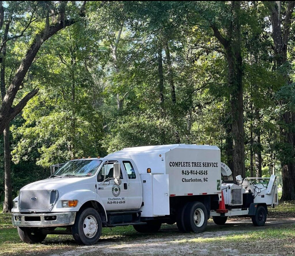 A white tree service truck with the Complete Tree Service, LLC logo and contact information, parked in Charleston, SC.