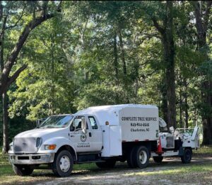 A white tree service truck with the Complete Tree Service, LLC logo and contact information, parked in Charleston, SC.
