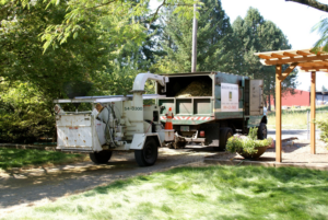 A Bridgetown Tree Service truck with a wood chipper and debris in the bed, ready for work in Portland, OR.