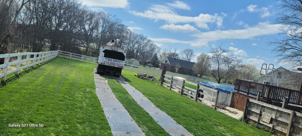 A Middle Tennessee Tree Service truck driving up a long driveway in Cookeville, TN.