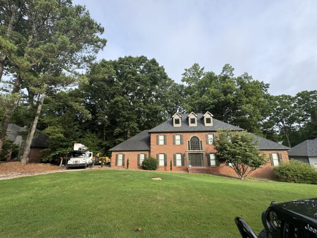 A tree service truck and equipment parked in front of a large residential home for a job by Golden Acres Tree Care LLC in Roswell, GA.