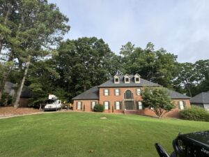 A tree service truck and equipment parked in front of a large residential home for a job by Golden Acres Tree Care LLC in Roswell, GA.