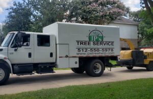 A JP'S Tree Service truck pulling a wood chipper, ready for tree work in Austin, TX.