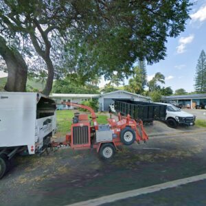 An Island Trees service truck with a wood chipper and dump trailer parked in Bethpage, NY.