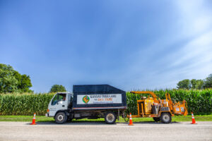 A Kansas Tree Care truck with a wood chipper attached, ready for debris removal in Lawrence, KS.