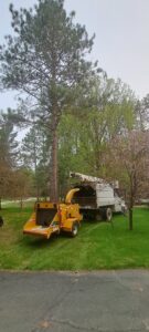 A tree service truck with an attached wood chipper ready for debris removal by Klee Logging & Tree Service Inc. in Green Bay, WI.